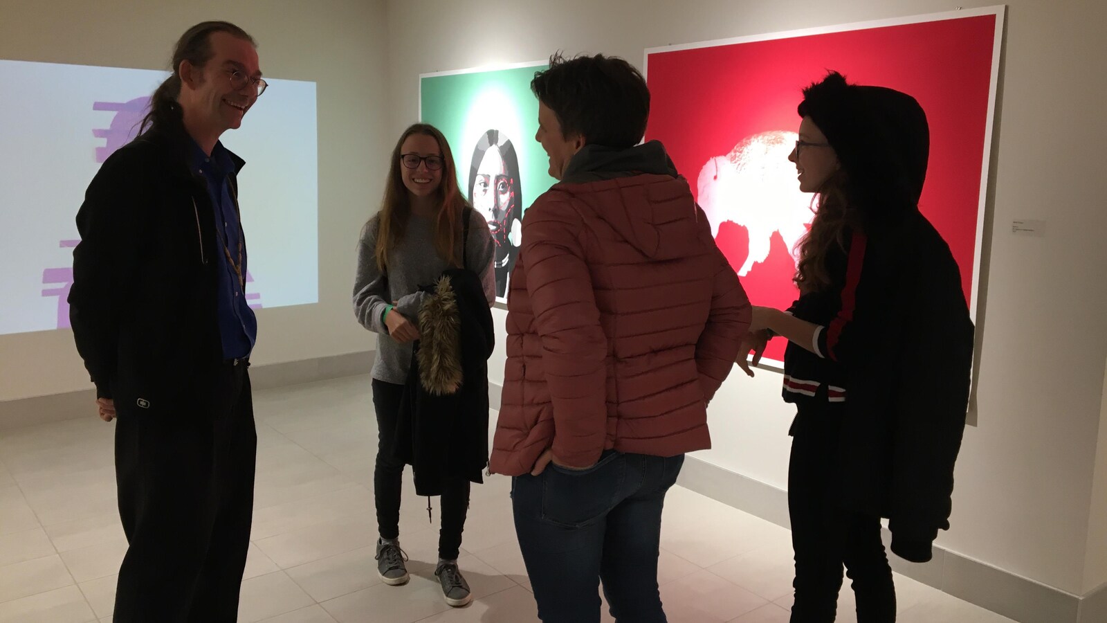 Trois touristes dans un musée discutent avec le guide.