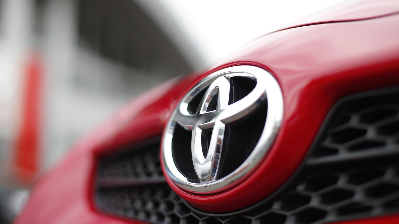 Le logo de Toyota sur le capot d'un véhicule rouge.