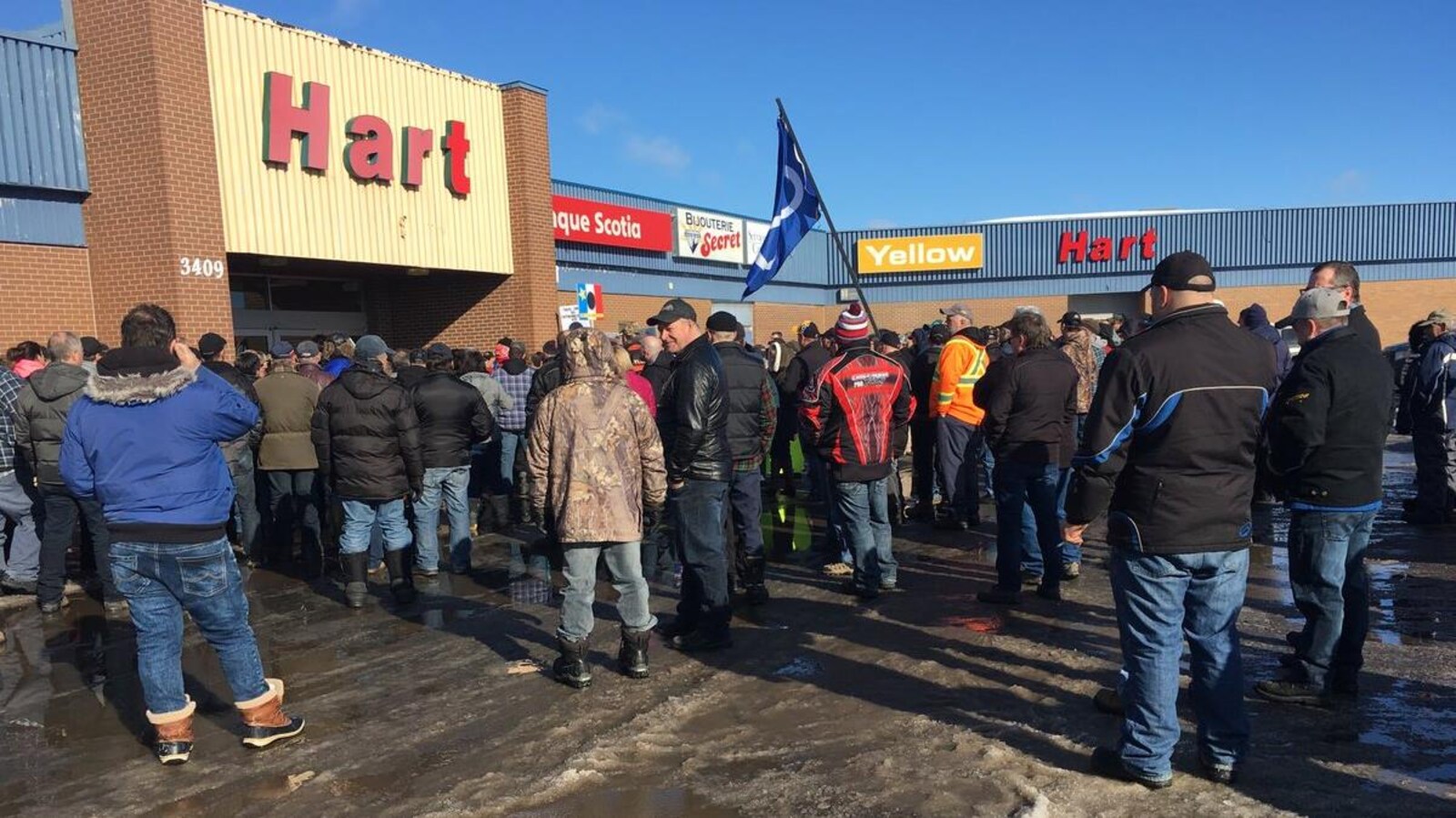 Des dizaines de manifestants devant un centre commercial