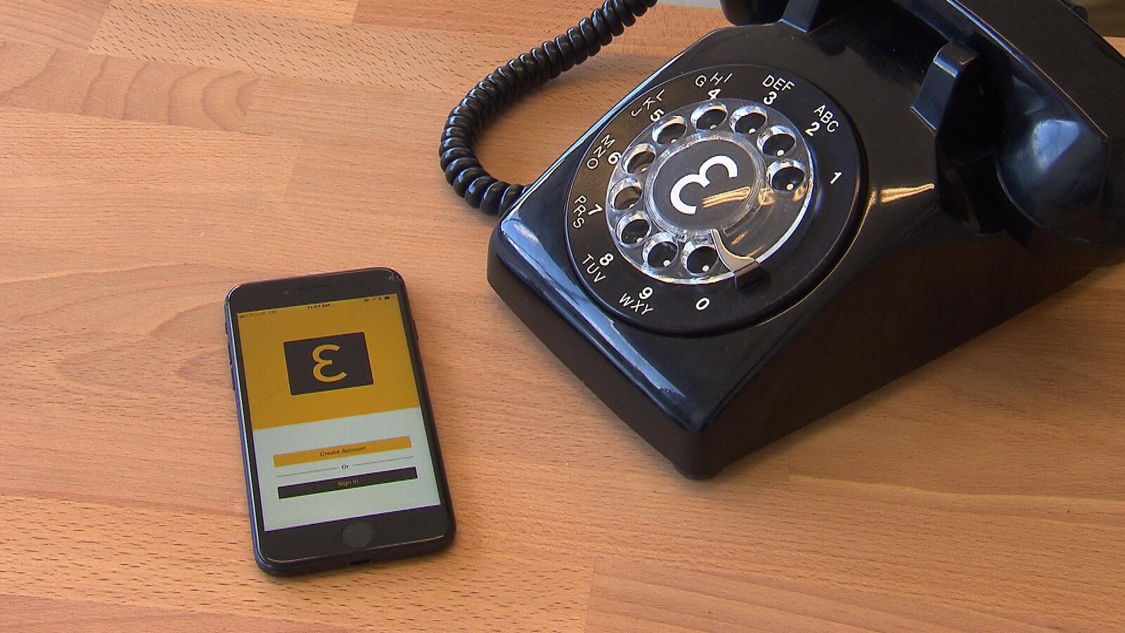 Un téléphone intelligent affichant le logo d'Eva aux côtés d'un téléphone à cadran.