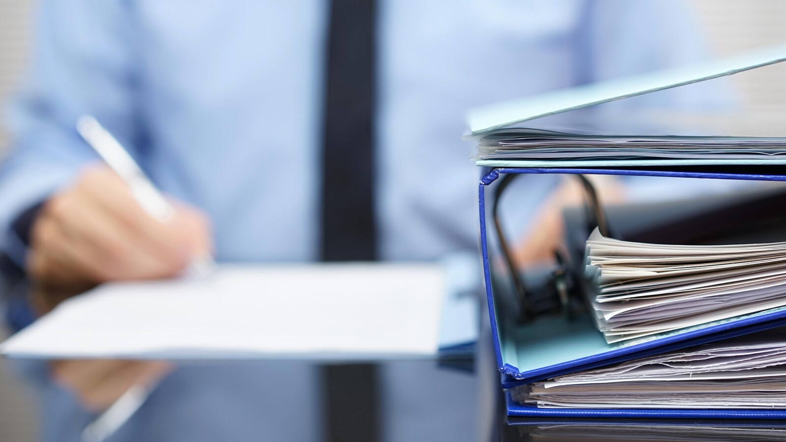 Un travailleur écrit sur une feuille de papier