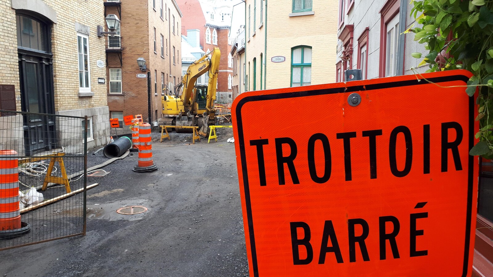 Chantier dans les rues du Vieux-Québec. On aperçoit, à l'avant, un panneau sur lequel est écrit « Trottoir barré ».