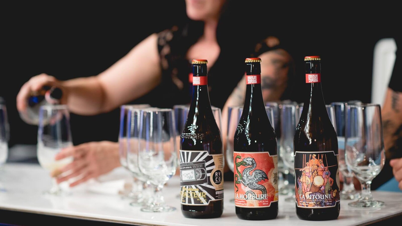 Une femme en train de verser des bières de la microbrasserie Le trou du diable.