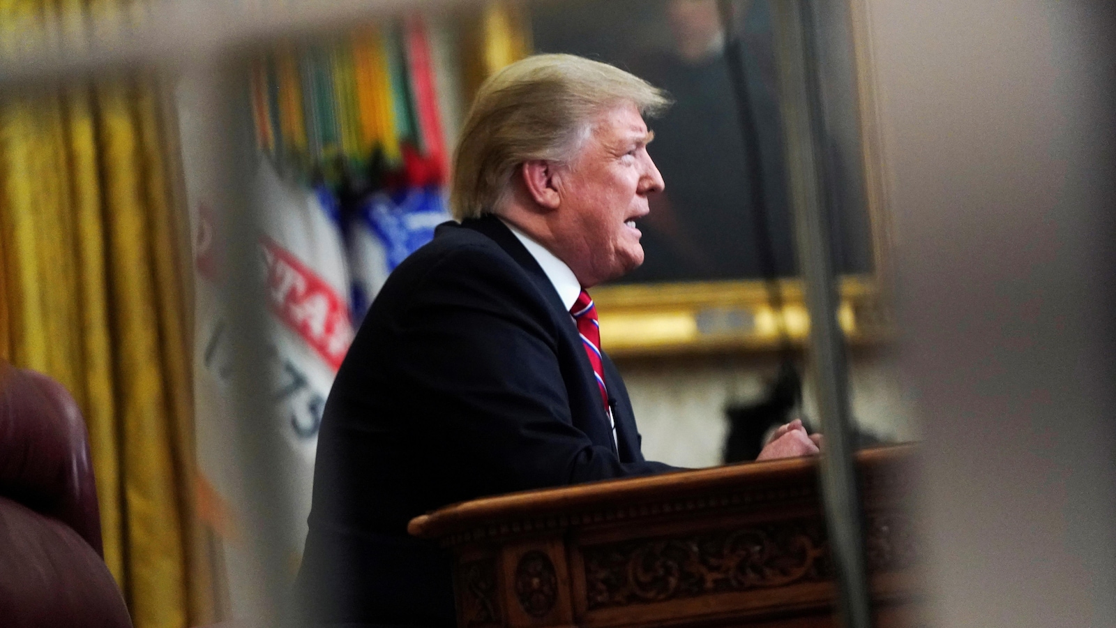 Le président Trump lors d'un discours, à travers l'une des portes vitrées du bureau ovale