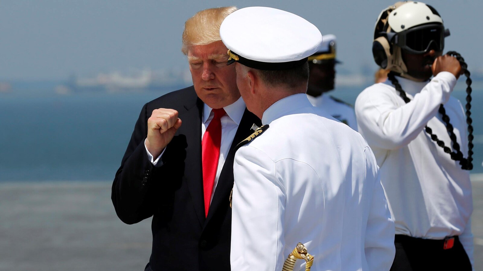 Le président américain salue le capitaine de la marine américaine, Richard McCormack, lors de l'inauguration du porte-avions Gerald Ford, le 22 juillet 2017.