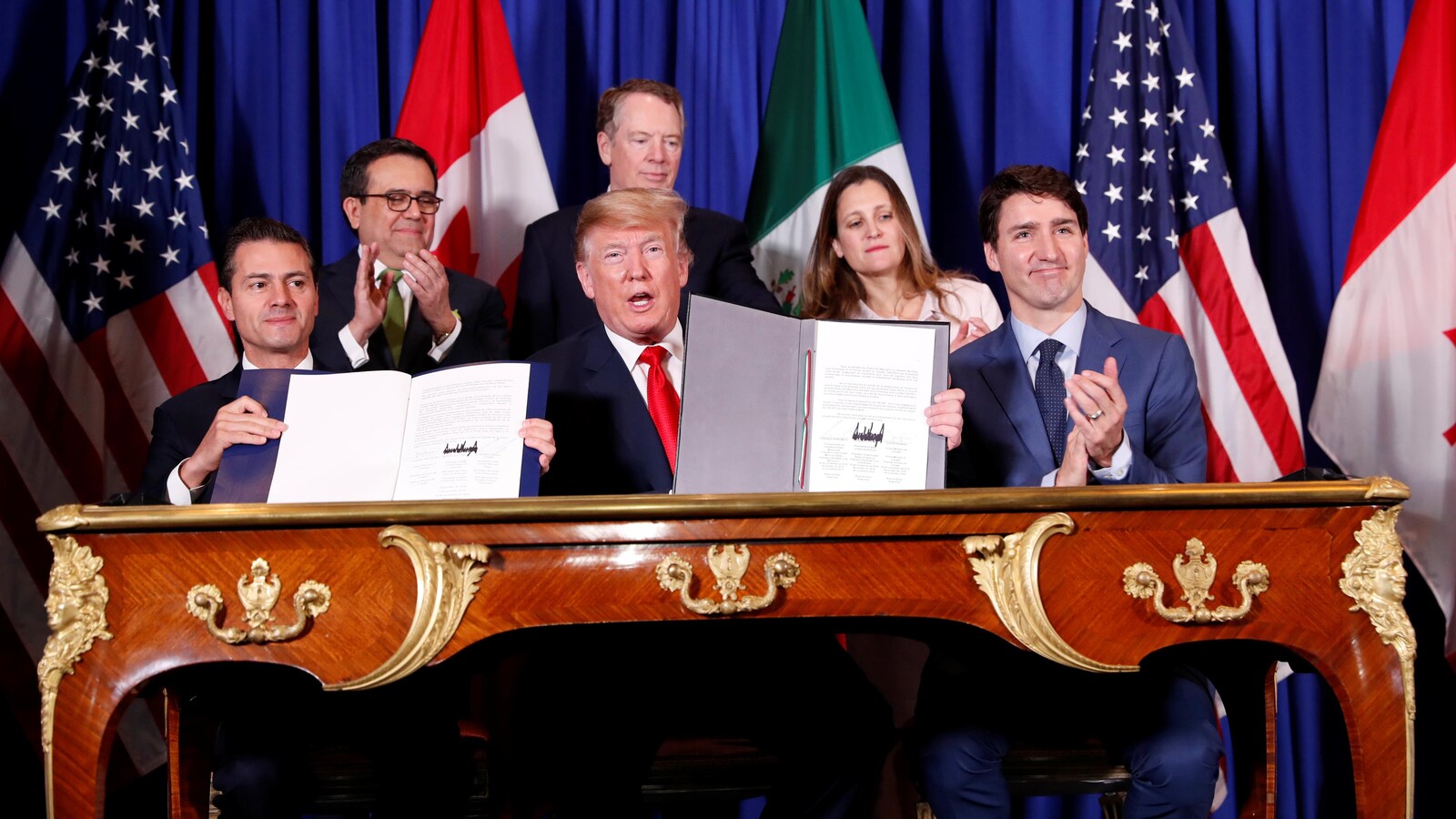 Donald Trump, Justin Trudeau et Enrique Pena Nieto assis à la table de signature du nouveau traité de libre-échange.