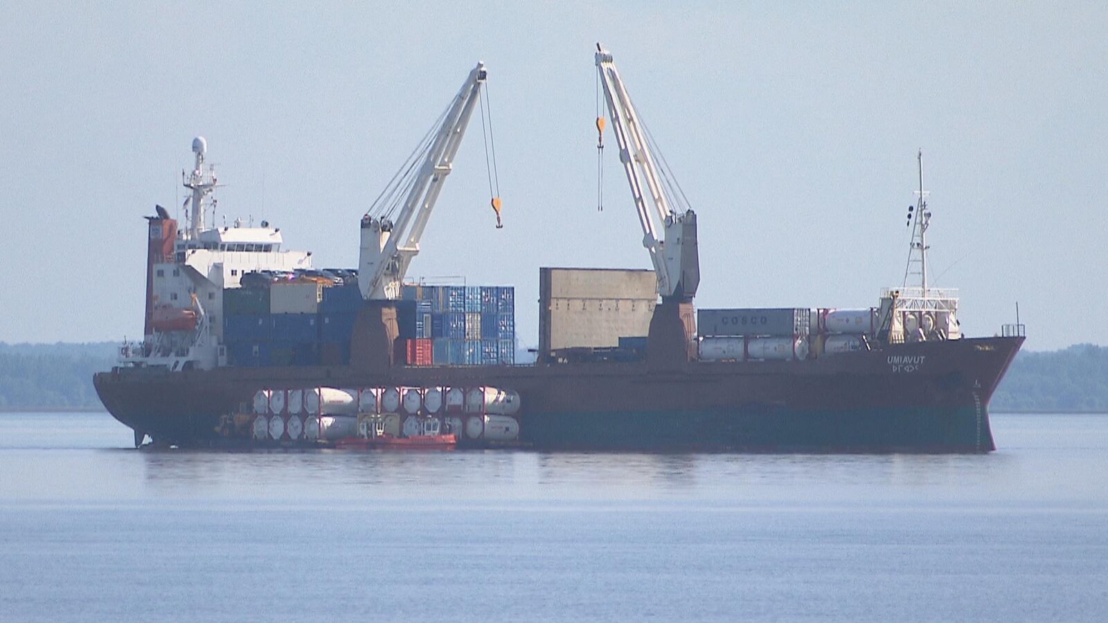 Des grues s'activent sur le cargo pour le décharger de sa cargaison.
