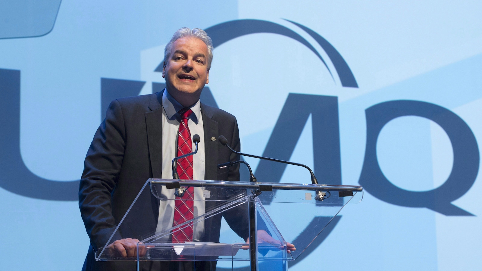 Le président de l'Union des municipalités du Québec, Bernard Sévigny, devant un lutrin pendant un discours