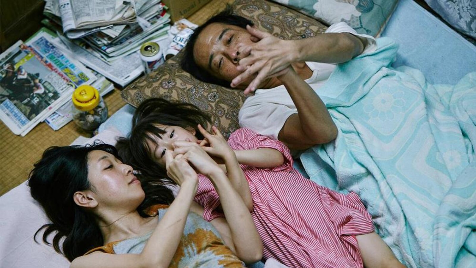 Deux adultes, une femme et un homme, entourent une enfant et comptent sur leurs doigts.