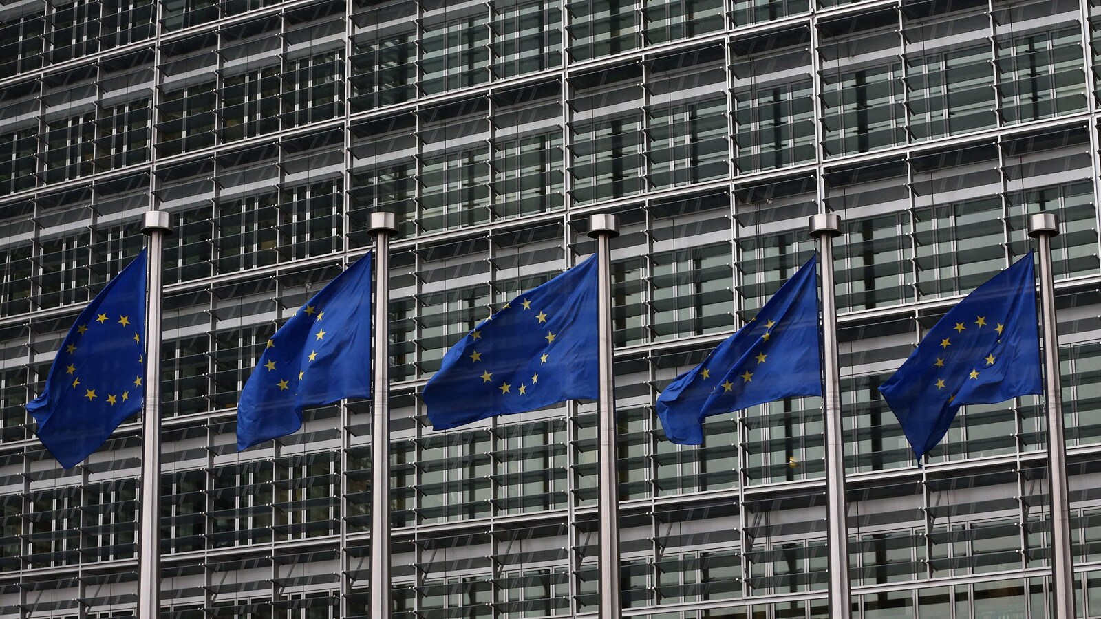 Des drapeaux de l'Union européenne flottent devant un édifice à Bruxelles.