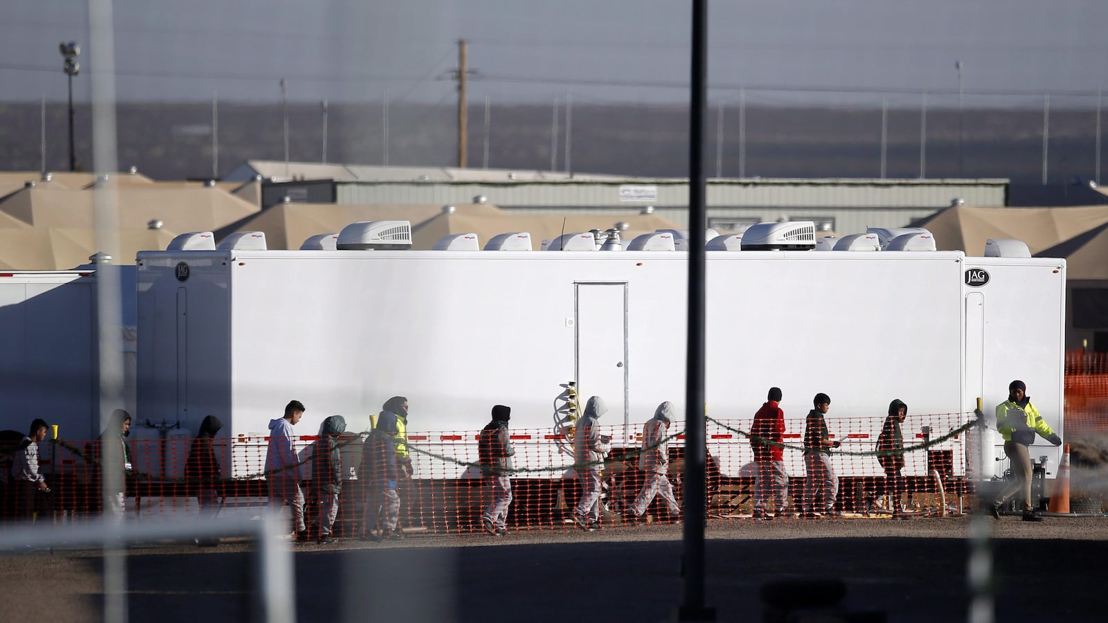 Des adolescents migrants marchent en file dans le camp de Tornillo au Texas.