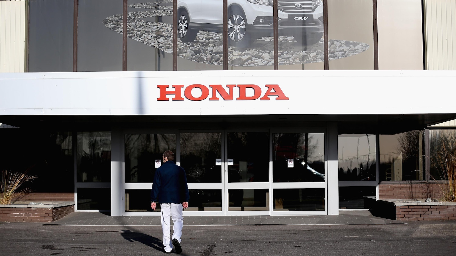 Un employé entre dans une usine de Honda.