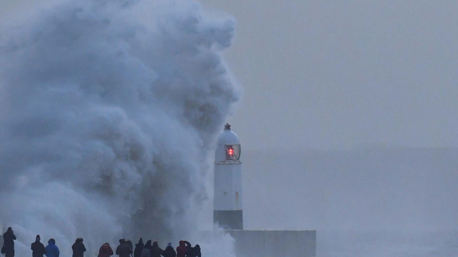 Une vague se brise sur le rivage.