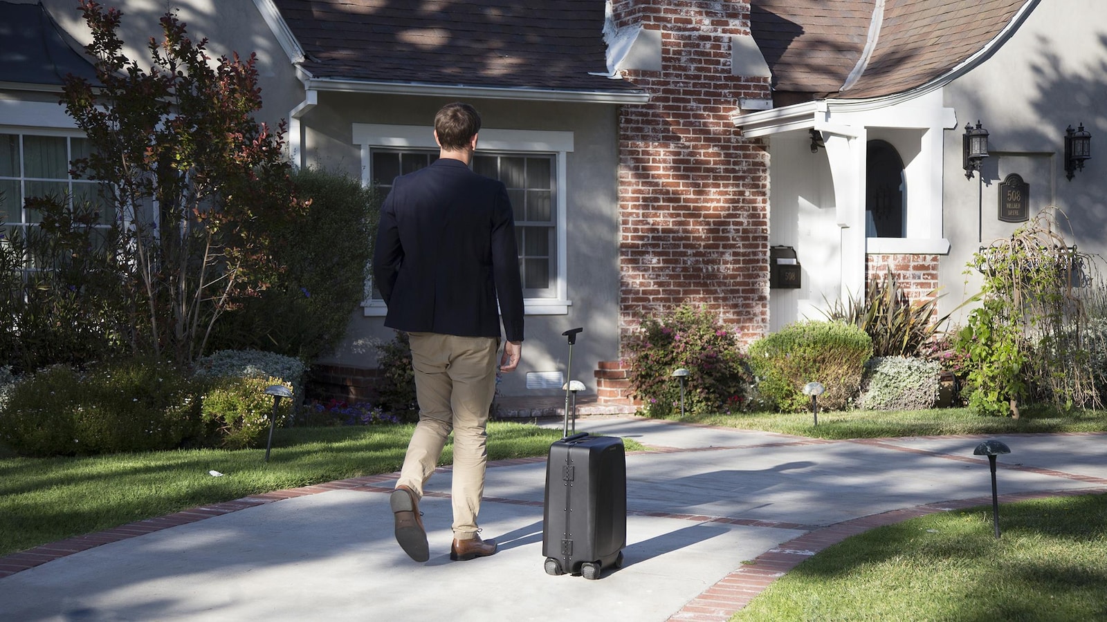Un homme marche suivi par une valise qui avance toute seule.