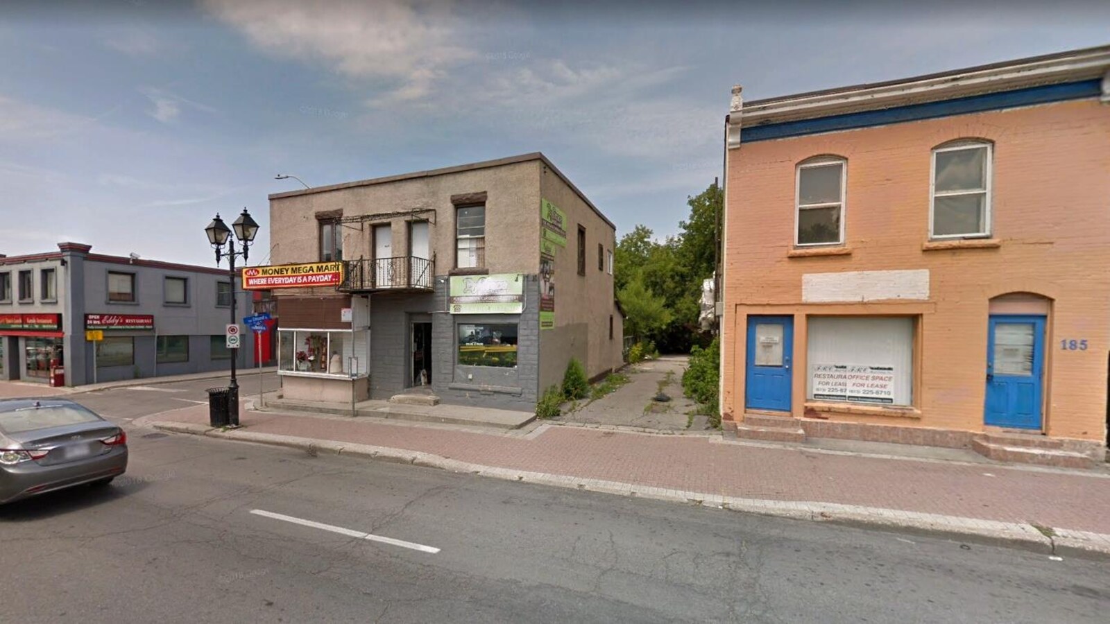 Vue de commerces et d'immeubles à partir de la rue.