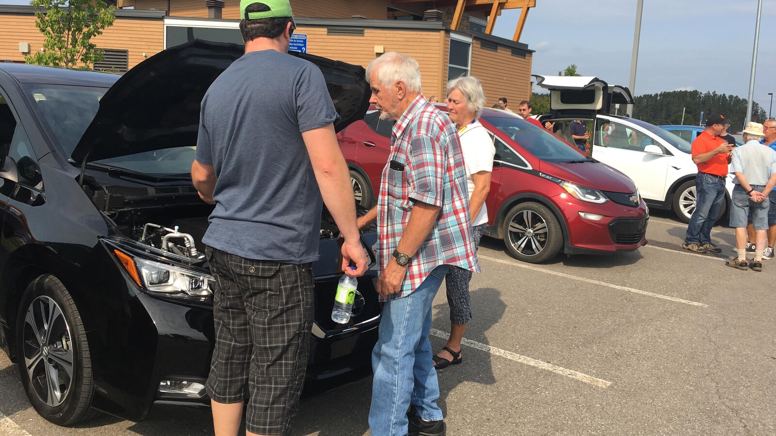 Des gens qui regardent sous le capot d'une voiture