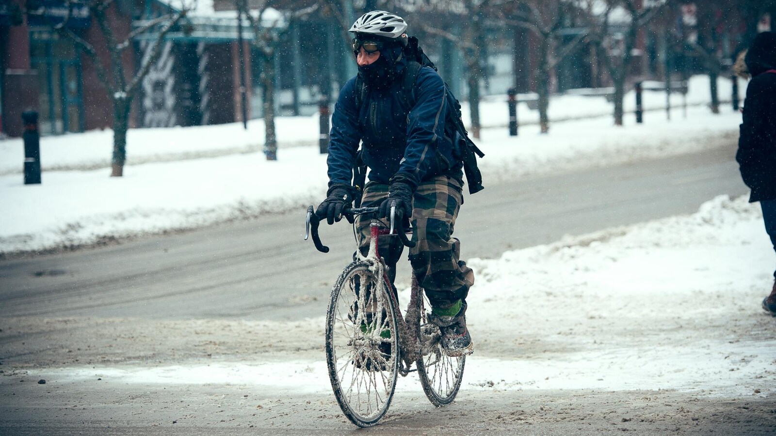 Un cycliste brave les éléments durant la saison froide.