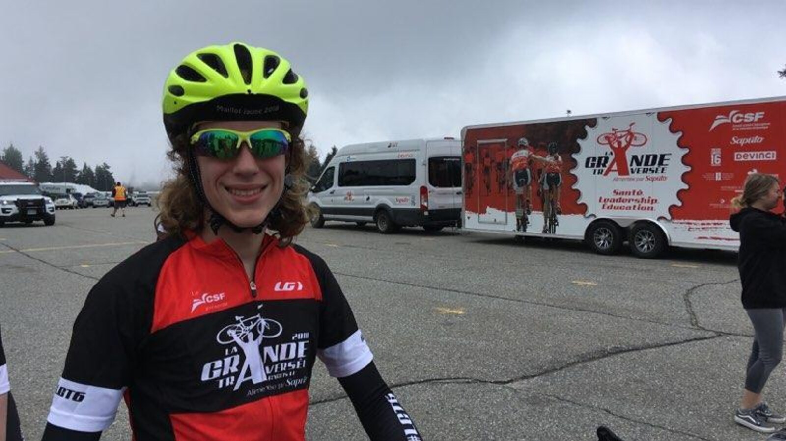 Portrait d'une jeune homme vêtu en cycliste avec casque et lunettes fumées .