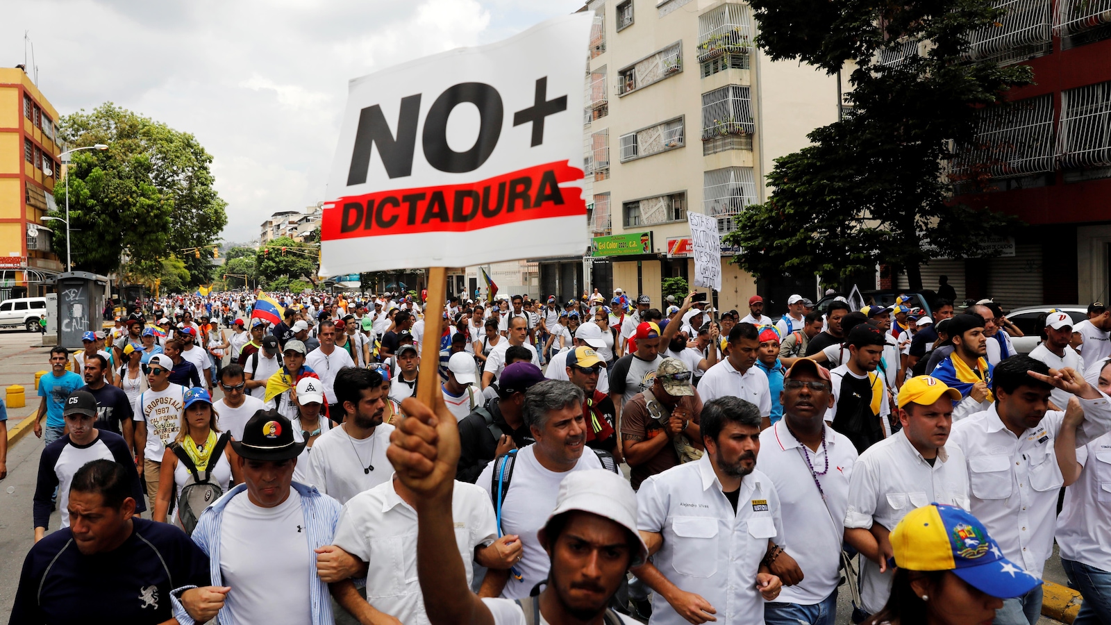 Un homme tient une pancarte « Non à la dictature » lors d'une marche qui a réuni des milliers de personnes à Caracas, au Venezuela.