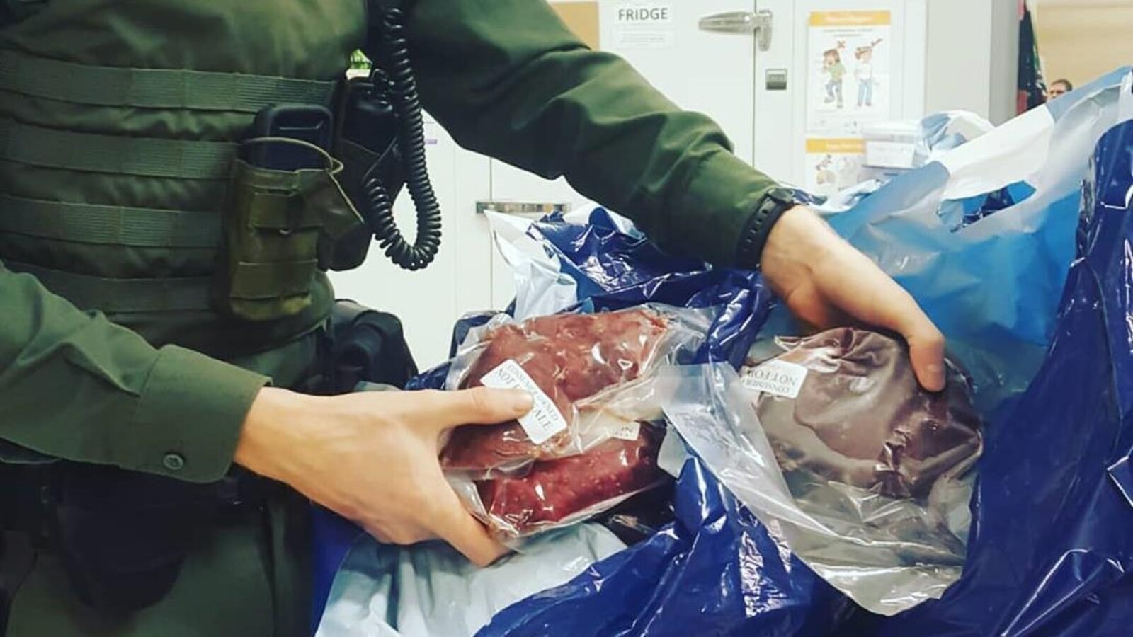 Une agente de conservation tient de la viande surgelée emballée.