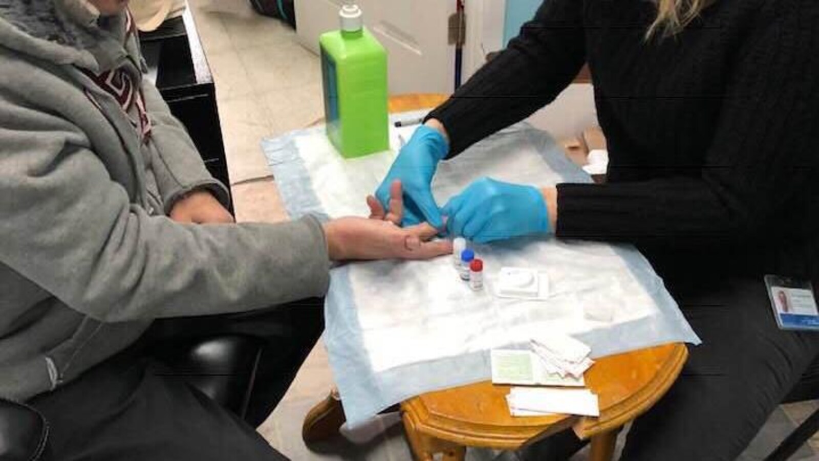 Une médecin pratique le test de dépistage du VIH sur un patient.