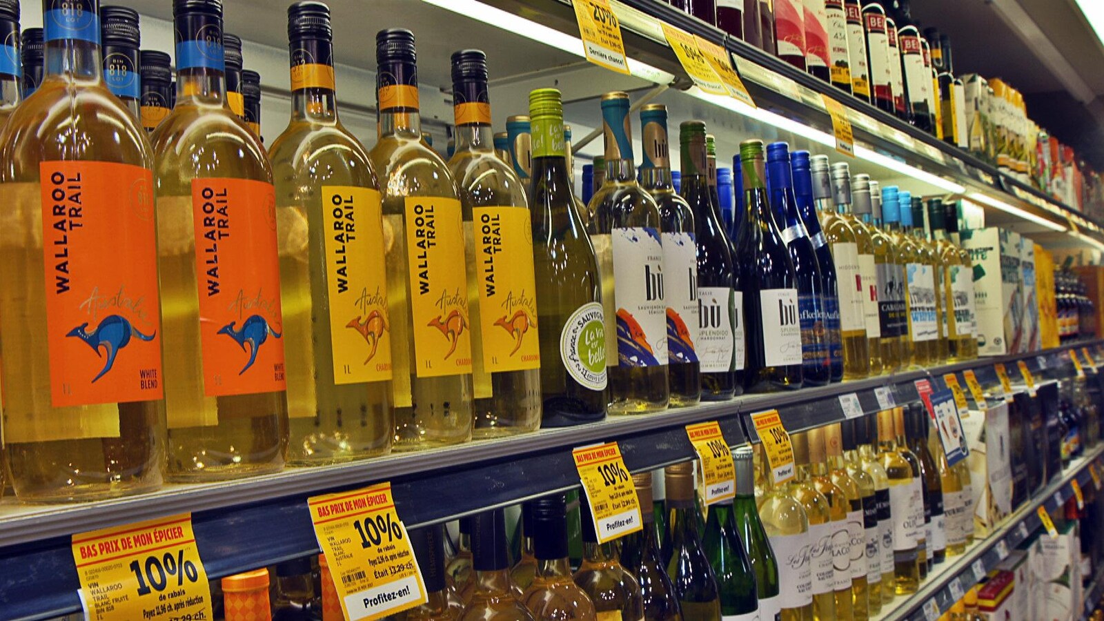 Des rangées de bouteilles de vin dans une épicerie