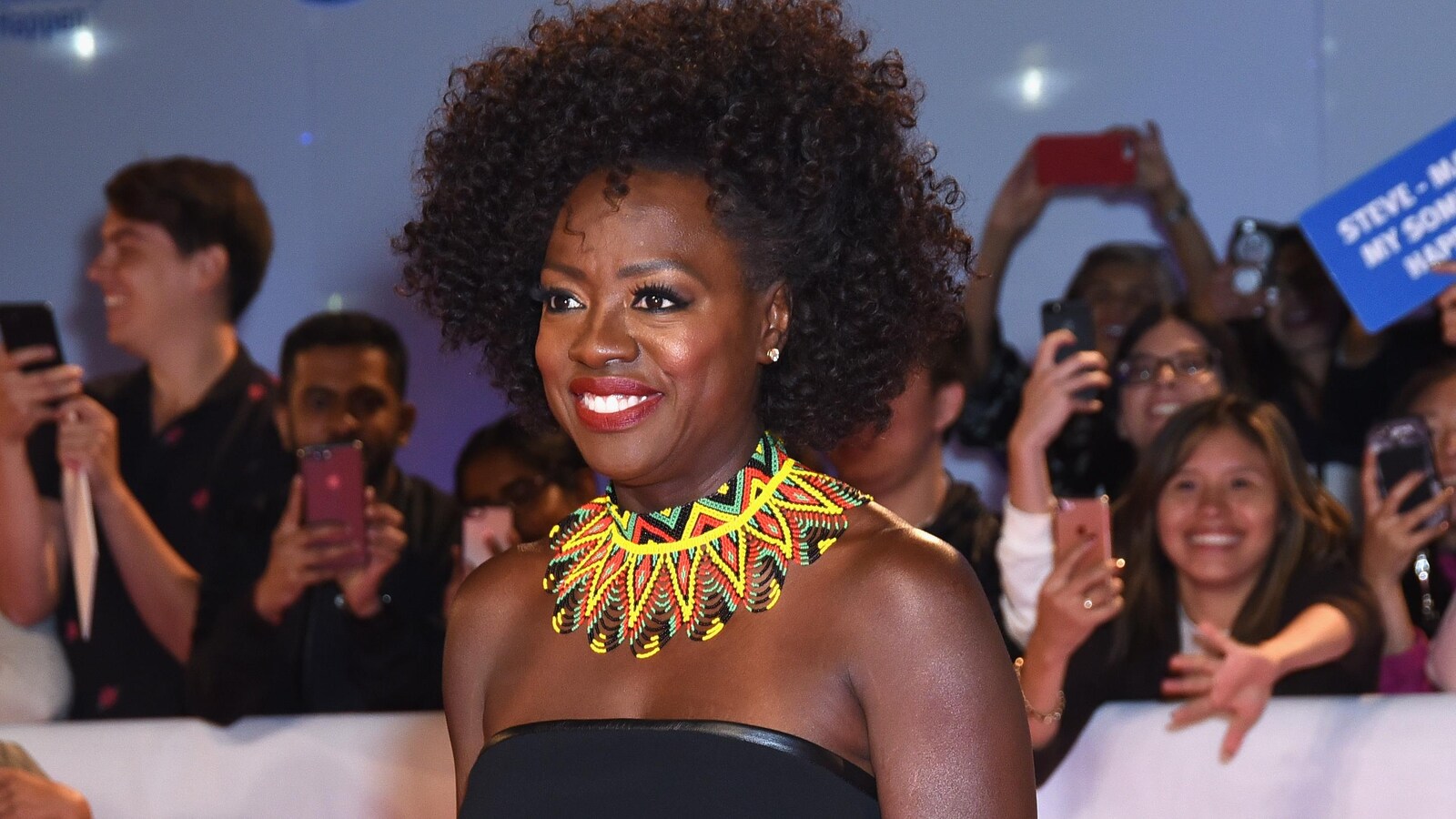 Viola Davis pose en souriant sur le tapis rouge.