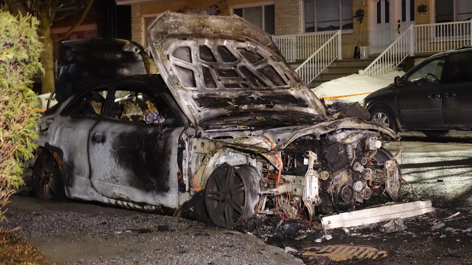 Un véhicule stationné et détruit par les flammes.