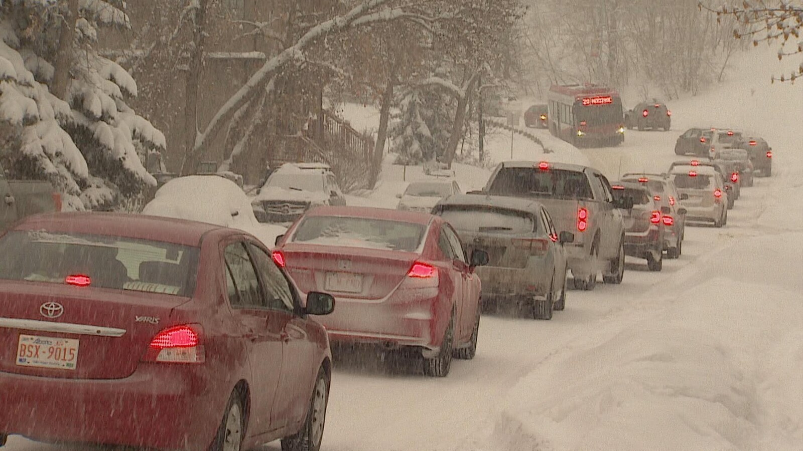Une file de voitures sous la neige