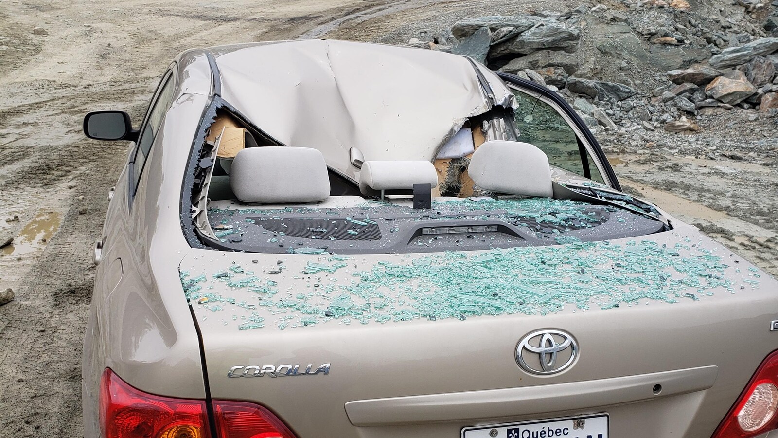 Une voiture dont le toit s'est écrasé et dont la vitre arrière est éclatée.