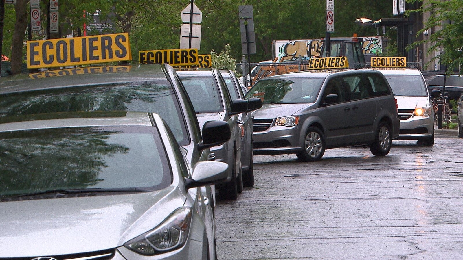 Des voitures de transport spécialisé font la file devant l'école primaire de L'Étincelle, le mardi 28 mai.