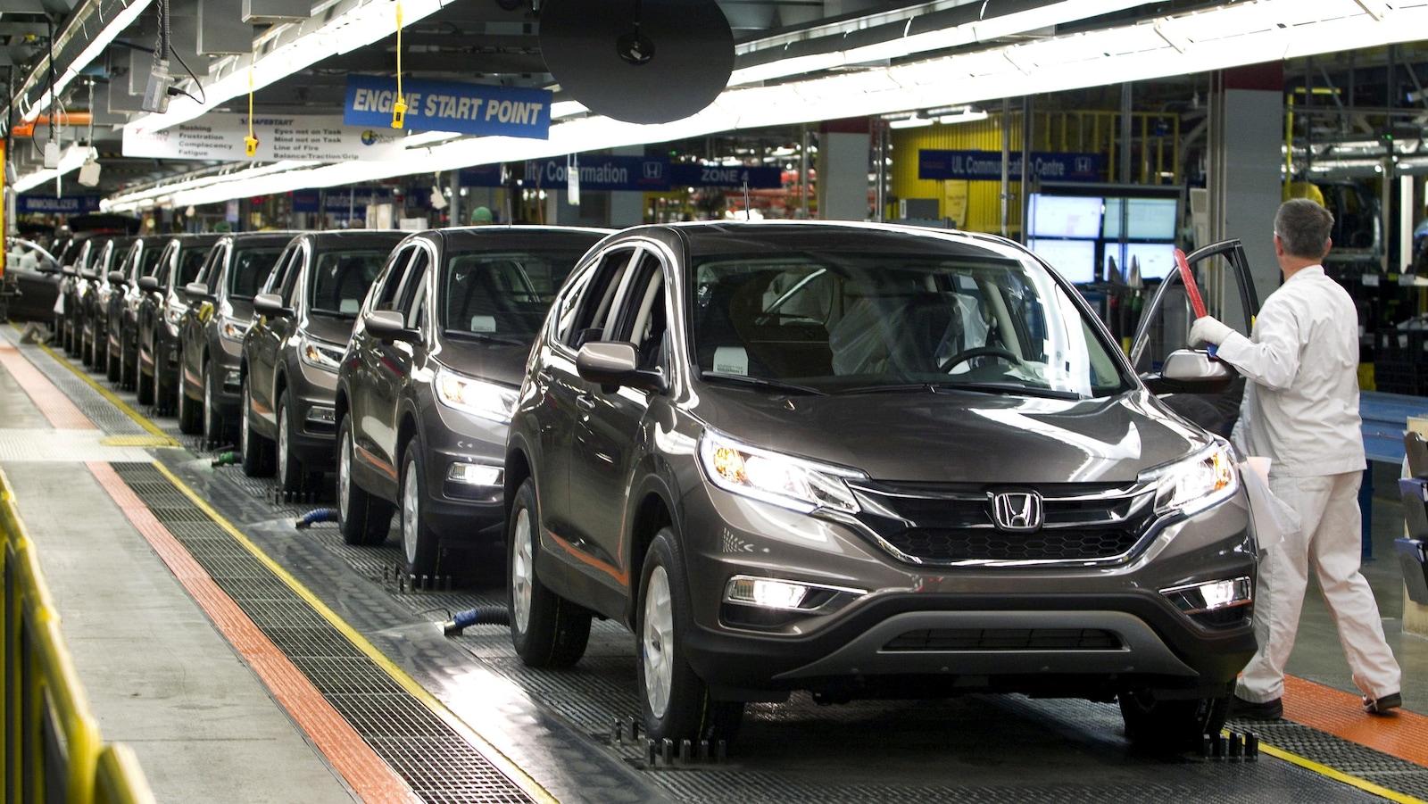 Un employé d'un fabricant automobile inspecte une chaîne de montage.