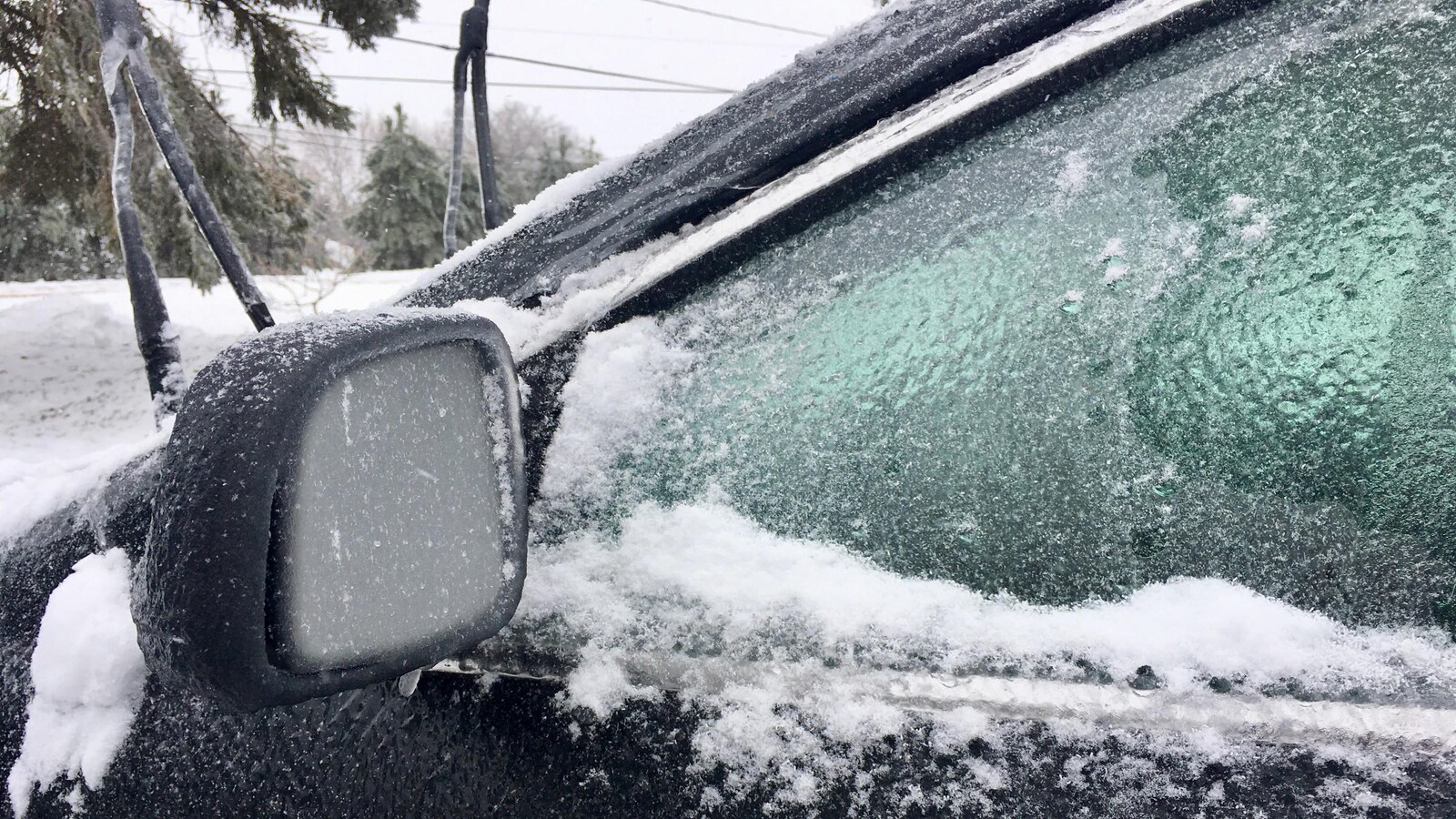 Gros plan d'un miroir et d'une portière sous le verglas