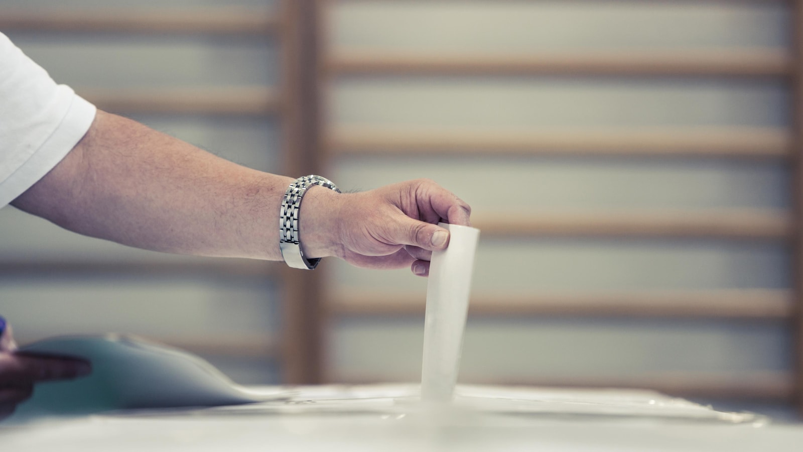 Un électeur place son bulletin de vote dans l'urne.