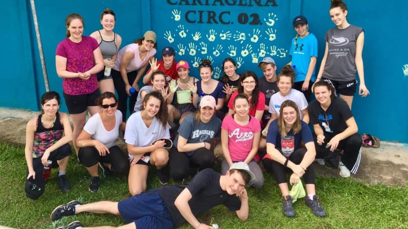 Un groupe d'adolescents pose devant un mur d'école au Costa Rica.