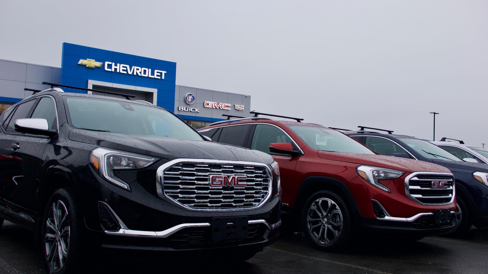 Des véhicules utilitaires sport sont exposés dans la cour d'un concessionnaire General Motors.