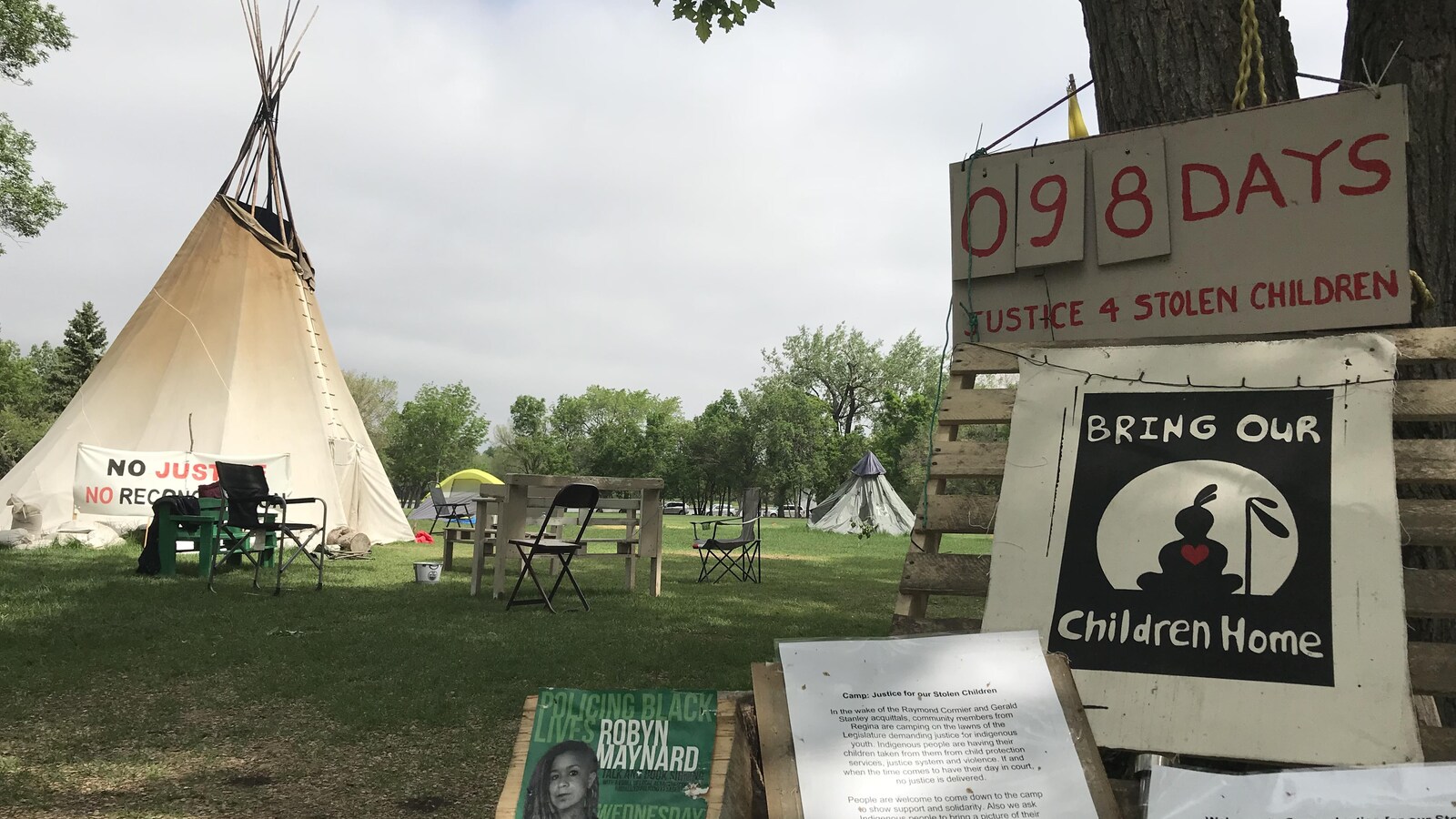 Des pancartes devant un tipi afin de réclamer la justice pour les enfants autochtones et un panneau qui compte 98 jours de protestation