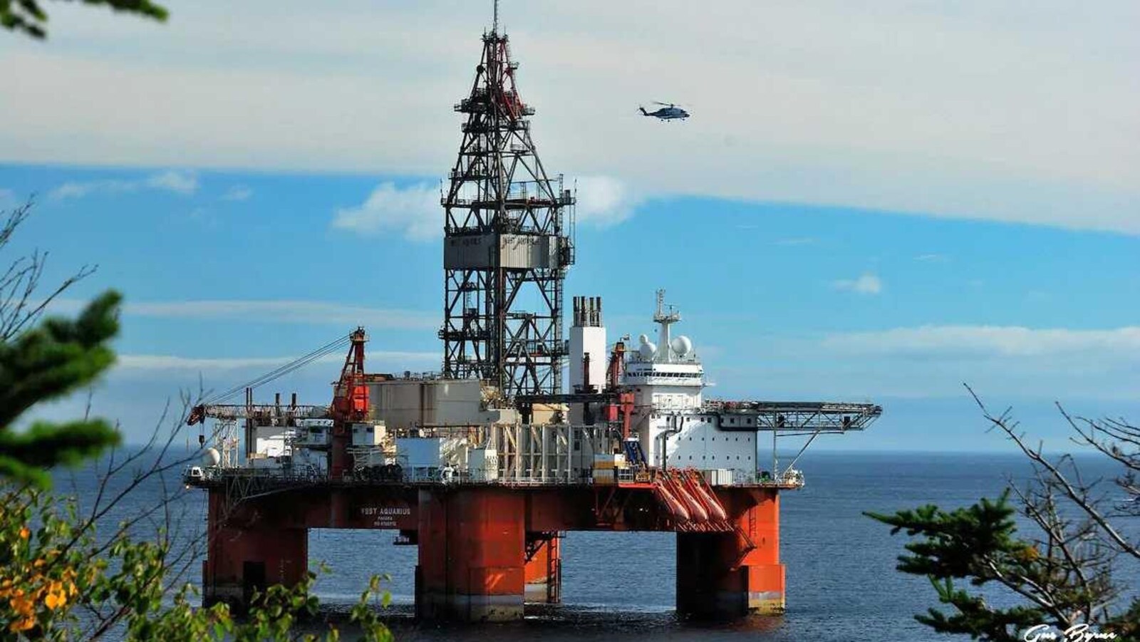 Plateforme de forage West Aquarius survolée par un hélicoptère.