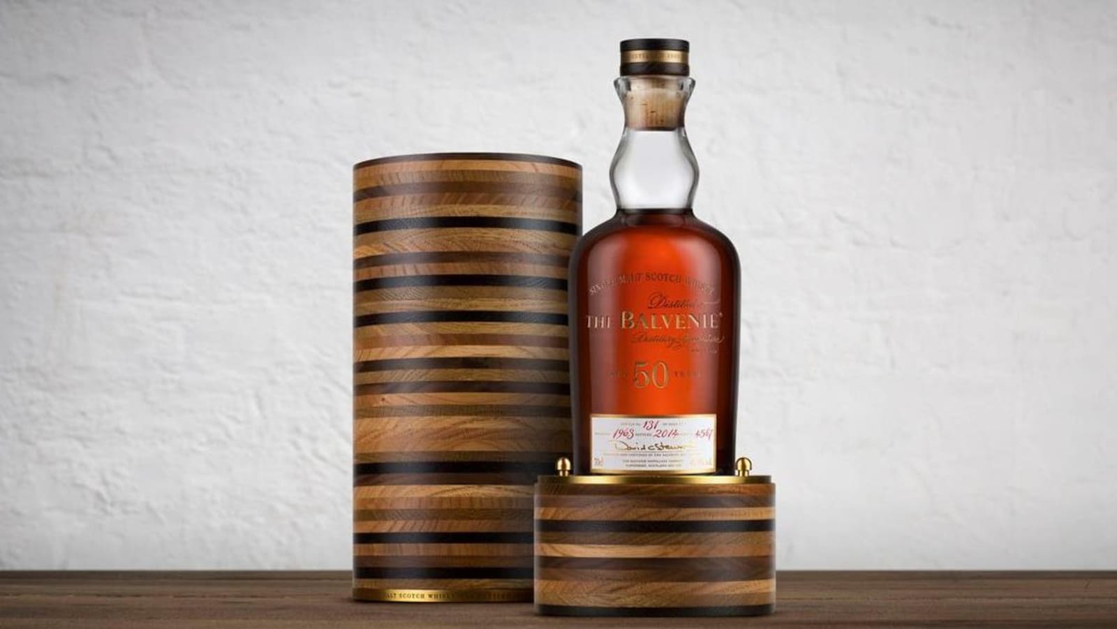 La bouteille est posée à côté de sa luxueuse boite. Le whisky est de couleur ambrée.
