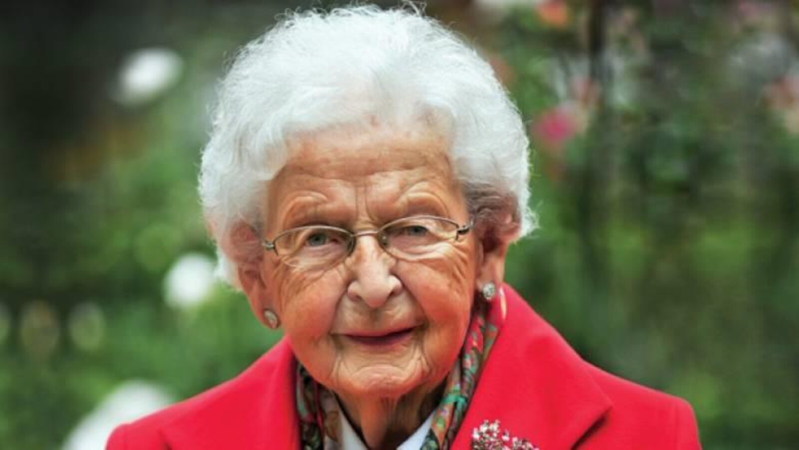 Portrait de Winnifred Irving vêtue d'un veston rouge.