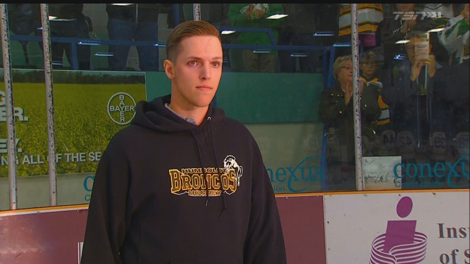 Une image de Xavier Labelle des Broncos de Humboldt. On le voit de face, il porte un chandail noir à capuchon avec le logo de l'équipe dessus