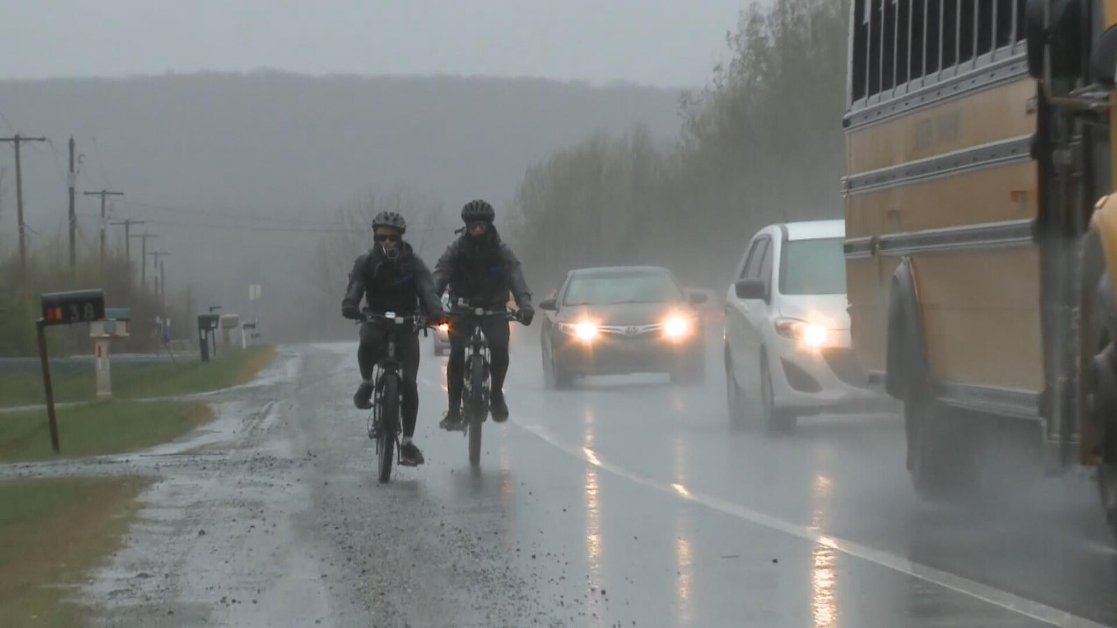 Le périple de Josué Simard-Lebrun et Xavier McConnell a commencé vendredi sous la pluie et dans le froid. On les voit ici rouler sur le bord de la route, complètement trempés