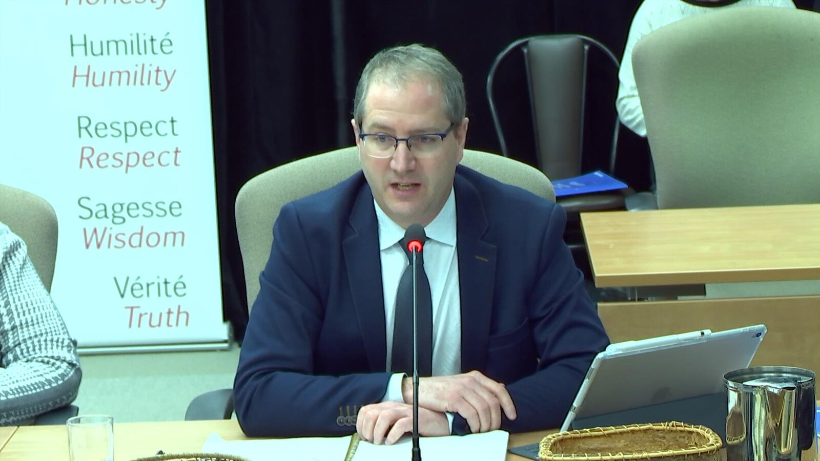 Un homme témoigne lors d'une commission d'enquête.