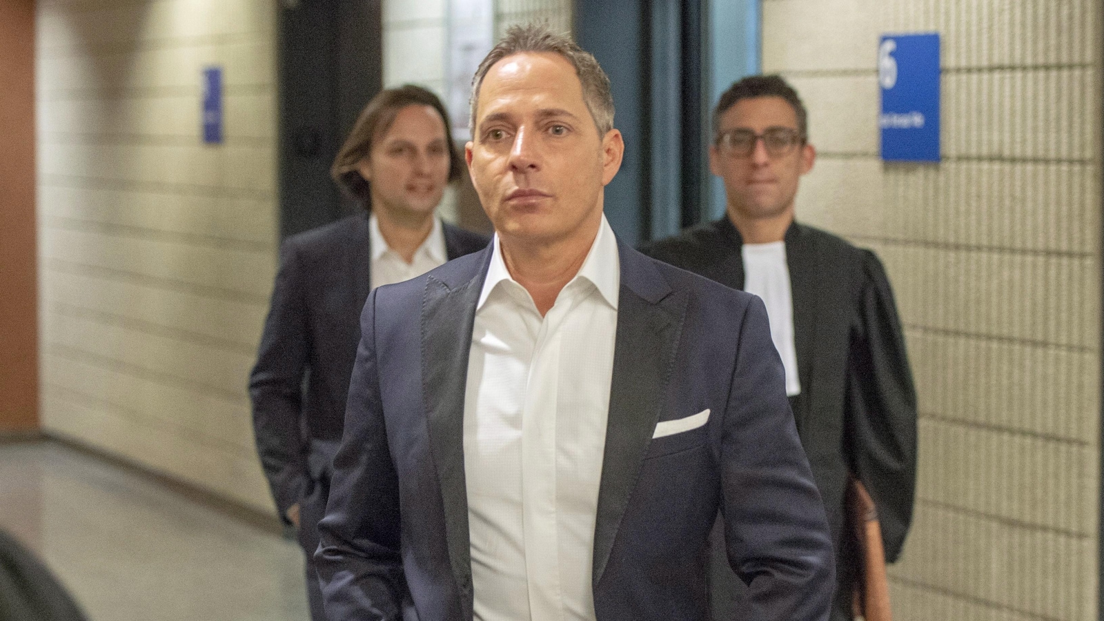 Yanaï Elbaz, Yohann Elbaz et un avocat marchent dans un couloir du palais de justice de Montréal.