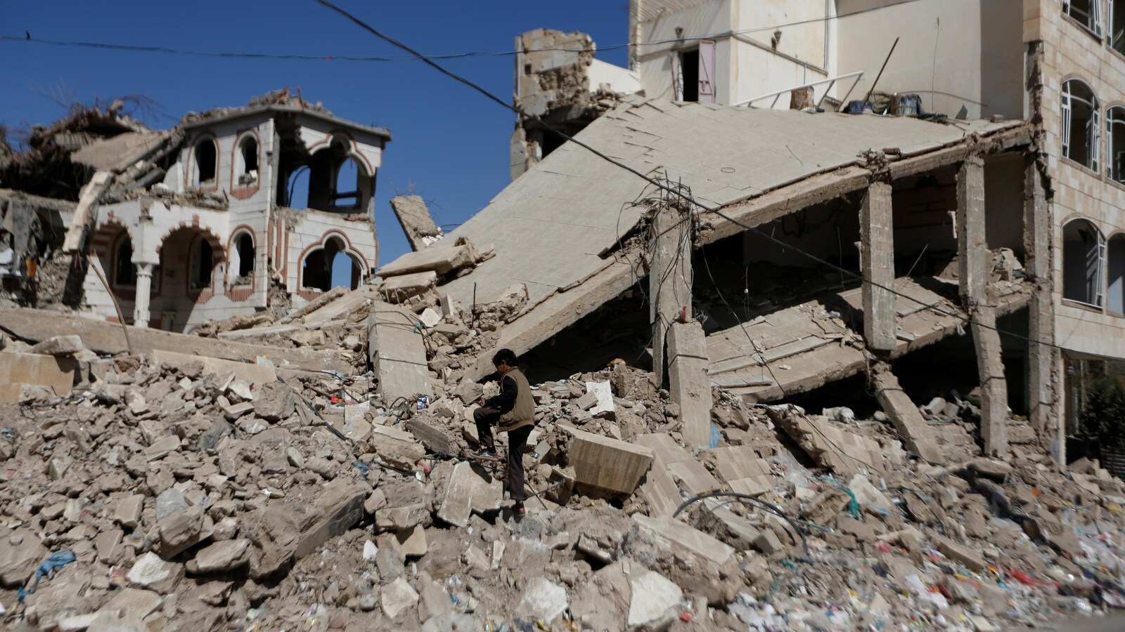 Un garçon marche sur les ruines d'un bâtiment, à Sanaa.