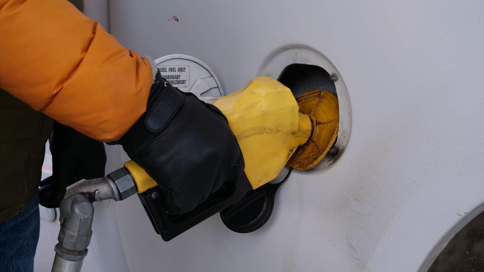 La main d'un automobiliste qui remplit son réservoir de diesel.