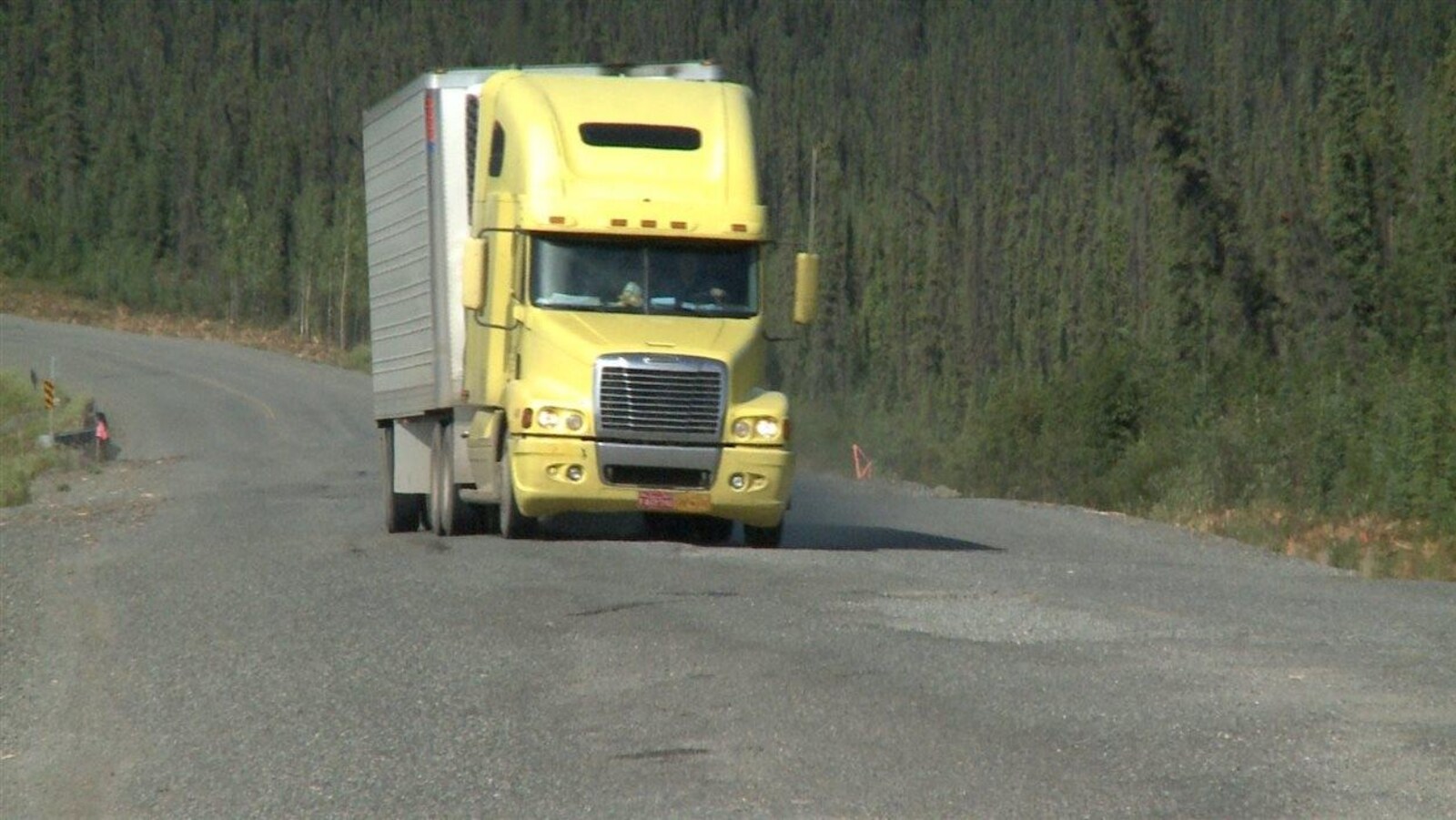 Un camion de transport tente d'éviter les trous sur la chaussée de la route de l'Alaska