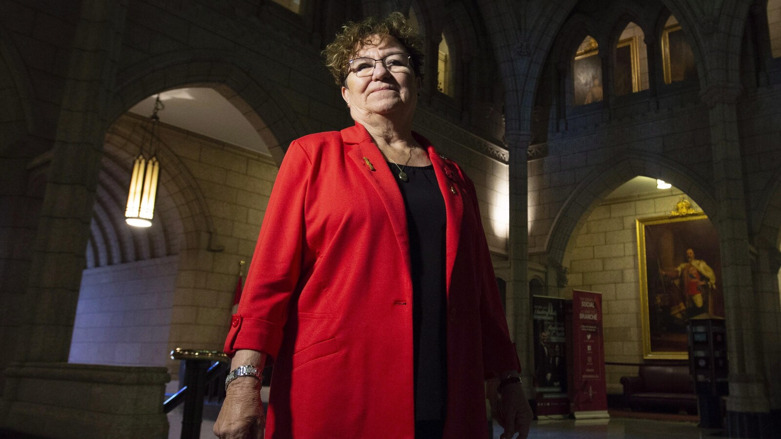 Yvonne Boyer debout, l'air confiant, dans le bâtiment du Parlement.