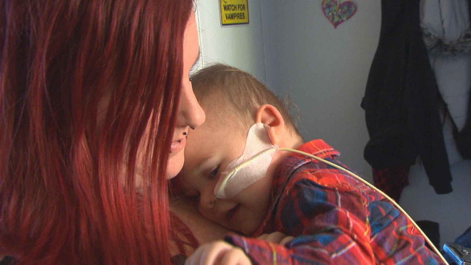 Une mère tient son enfant dans ses bras, la tête sur sa poitrine.