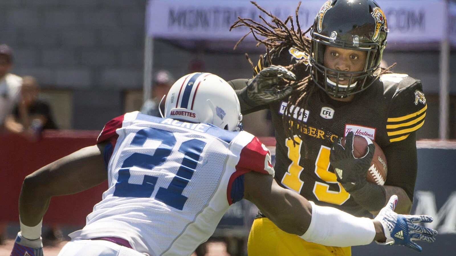 Le secondeur des Alouettes Chris Ackie et porteur de ballon des Tiger-Cats